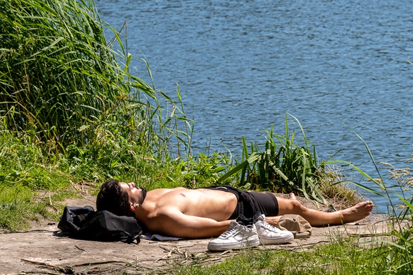 Mann liegt in der Sonne am Blauen See im Natur- und Erholungsgebiet De IJzeren Man