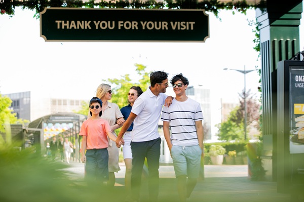Visitors walking outdoors at Designer Outlet Roermond on a sunny day.