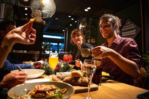 Groep vrienden is een hapje aan het eten in Roermond tijdens de feestdagen