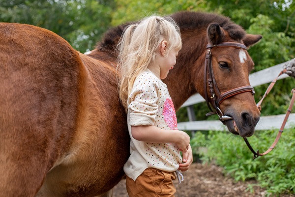Meisje staat bij haar pony
