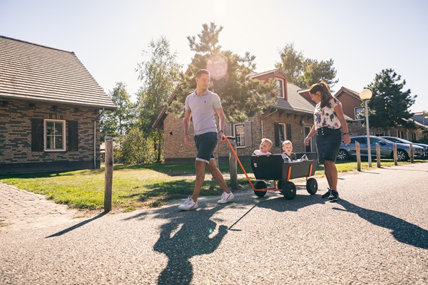 Gezin wandelt met de bolderkar over het vakantiepark Weerterbergen