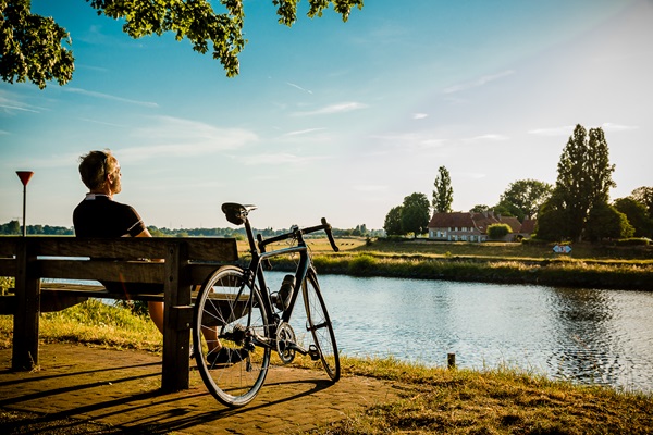 Man is tijdens het wielrennen afgestapt om van het mooie uitzicht te genieten in Stevensweert