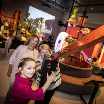 Kind en volwassenen ontdekken interactieve opstellingen in het Limburgs Museum tijdens een dagje uit met het gezin.